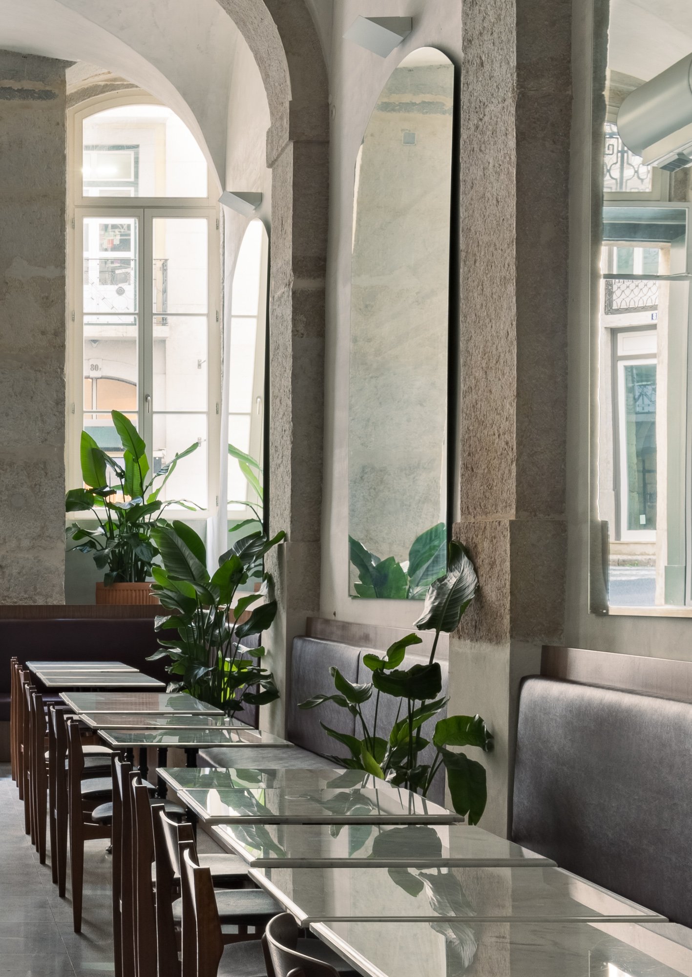 Side view of dining area with glass tables and leather banquettes