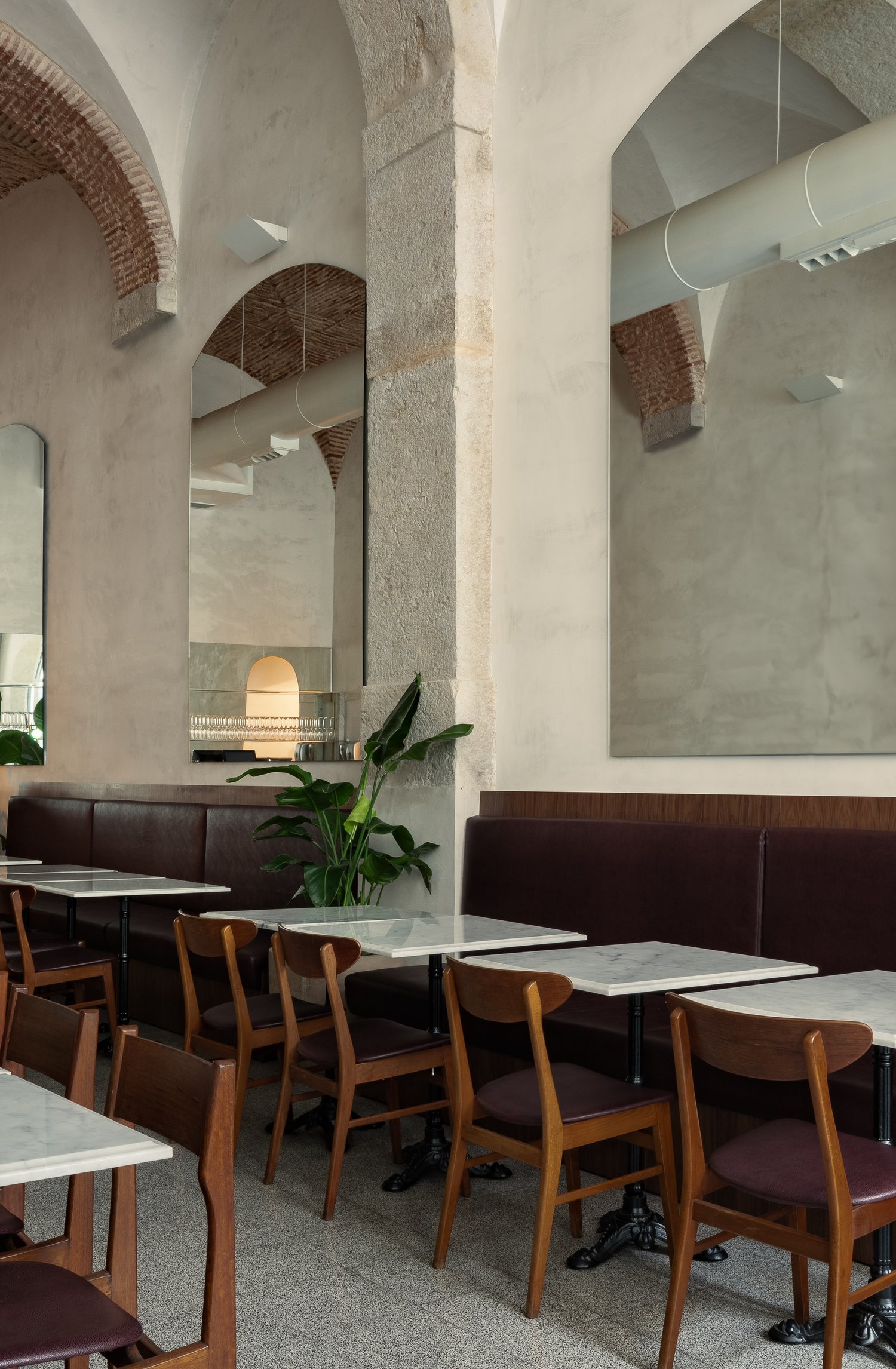 Dining area with mid-century modern wooden chairs and marble tables